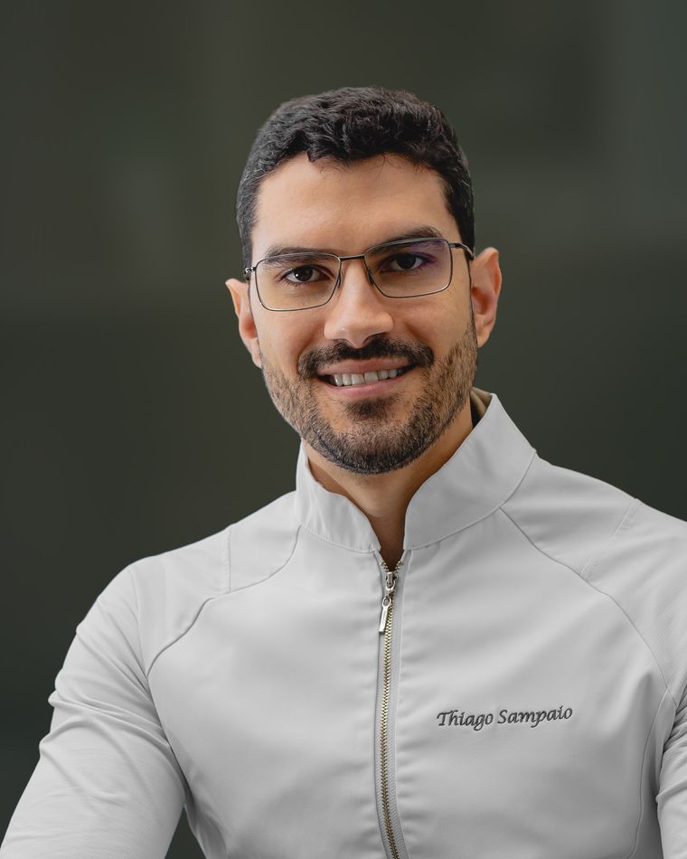 Thiago Sampaio, nutricionista, de jaleco, sorrindo